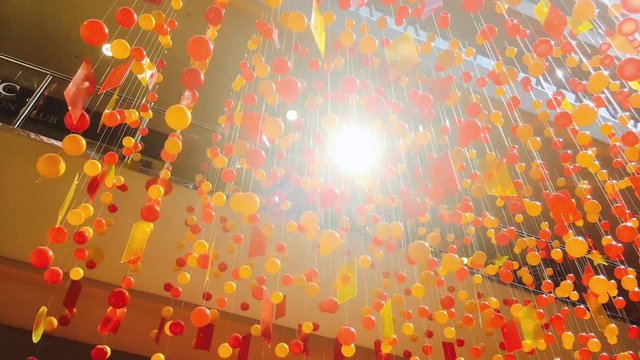 Hanging decotation from plastic balls and plates moving shining on sun