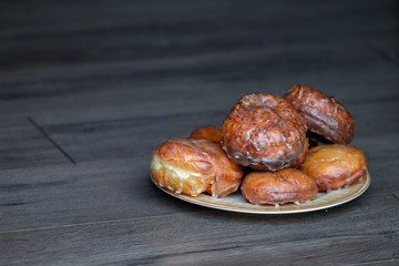 A bunch of donuts on a plate waiting to be eaten