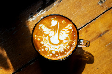 coffee latte art swan shape on wood table,aerial view