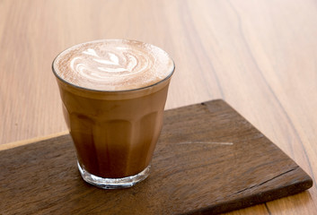 Hot latte and beautiful art latte on wooden floors