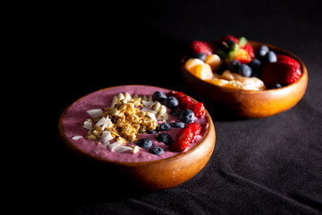 Smoothie bowl with fruits in wooden bowl