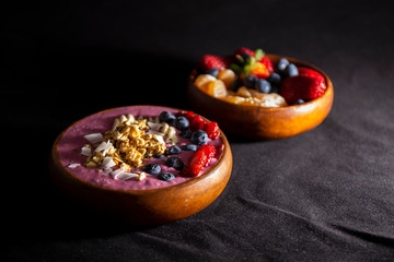 Smoothie bowl with fruits in wooden bowl