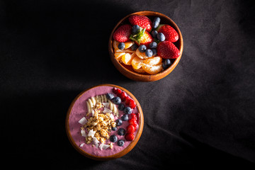 Smoothie bowl with fruits in wooden bowl