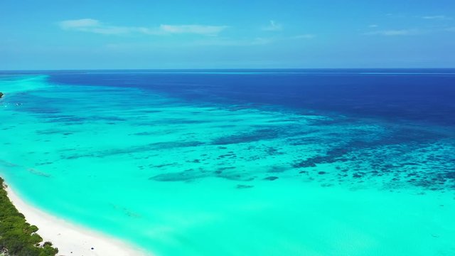 Flying by a tropical island of Barbados. The truck left, revealing the island. Turquoise water.