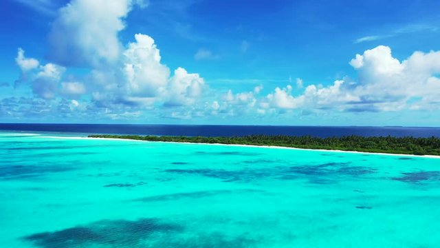 A dramatic sky above Indonesia. Flight towards an exotic island with trees on it. Turquoise water in front of it. Blue water behind it. Dolly in