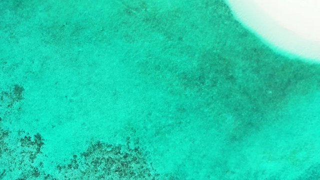 Flying over the turquoise aqua and a sandbank in Hawaii. Dolly in