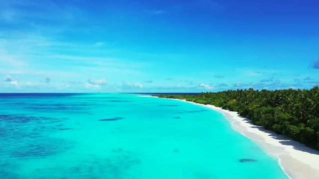 Slow flight over the turquoise pacific ocean along an island in Hawaii. Dolly in