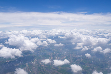 Beautiful scenery of sky, white clouds and land looking from window on airplane. Space for text