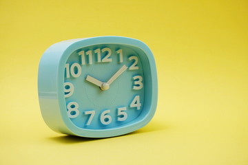 light blue alarm clock on yellow background