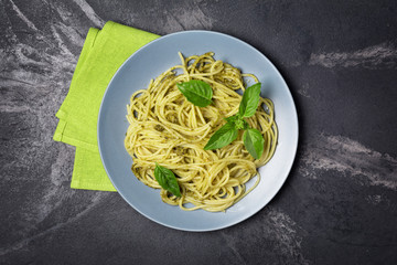 Spaghetti pasta with pesto sauce and basil
