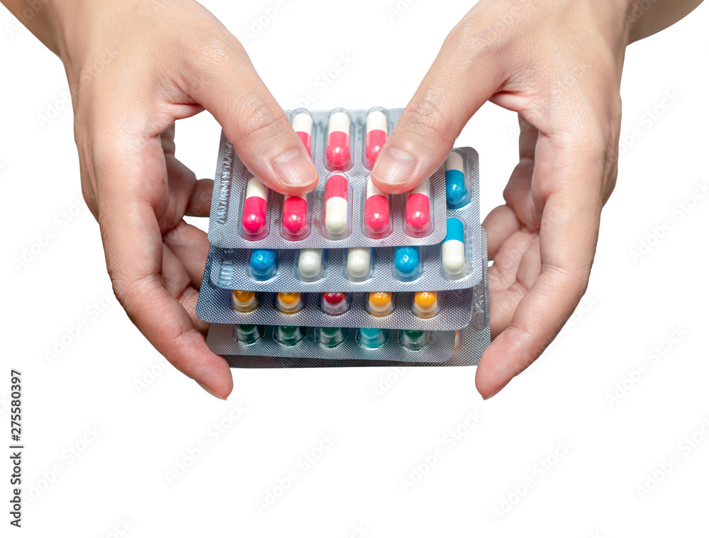 Wall mural woman hand holding pack of antibiotic capsule pills isolated on white background. give or receive dr