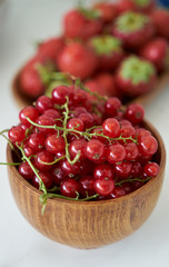 Red currant berry in a wooden bowl, close-up. Fresh currant fruit