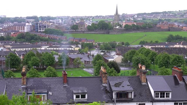 The cityscape of Londonderry (aka Derry) in Northern Ireland is shown from an elevated, static view during the day.
