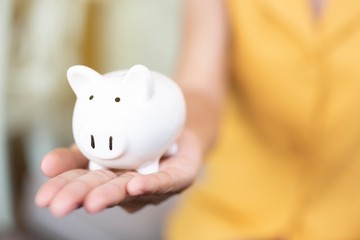 Women hand holding a pig's piggy bank. Money saving concept.