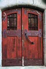 Old red door with wrought iron bolts.