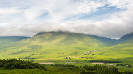Fototapeta na wymiar A Scottish Highland Landscape depicting a cloud-capped mountain scene.