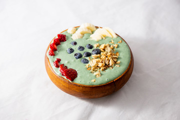 Spirulina yogurt with fruit in wooden bowl