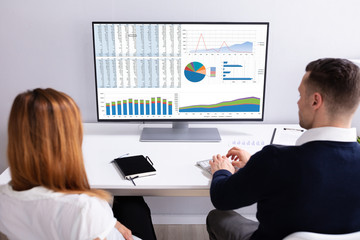 Businesspeople Analyzing Graph On Computer