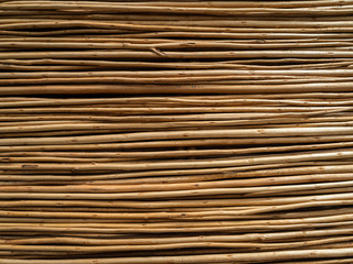 A fence made of thin branches. Related tree branches. A lot of wooden rods