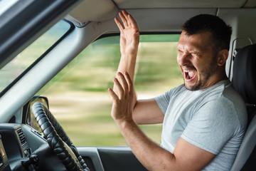 Portrait of a screaming young business man getting into car accident while driving