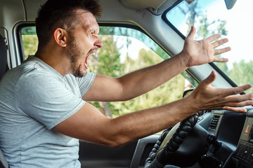 Aggressive Man, the driver of the car is outraged at the wheel during the trip. Emergency, accident, violation of rights, dispute, bad driver - obrazy, fototapety, plakaty