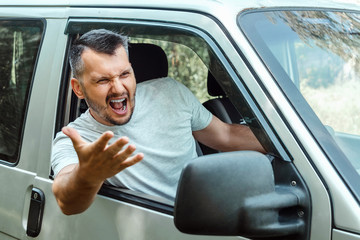 Aggressive Man, the driver of the car is outraged at the wheel during the trip. Emergency,...