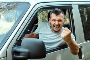 Aggressive Man, the driver of the car is outraged at the wheel during the trip. Emergency, accident, violation of rights, dispute, bad driver
