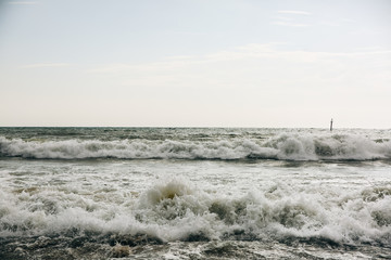 Buoy in the sea waves with foam. Empty beach. Summer vacations travel. Stormy ocean.