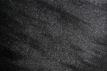 Black asphalt background texture with shadow for graphic design purpose