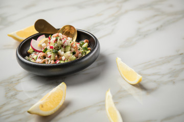 Norddeutscher Friesischer Nordseekrabben Salat in Schale mit Gurken, Radieschen, Zwiebeln, Dill und Zitronen auf Marmor Tisch