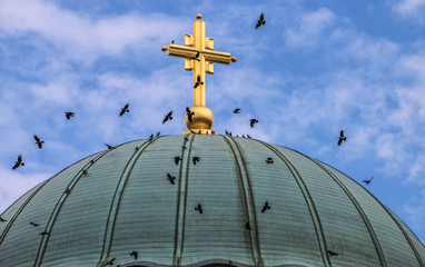 Fototapeta na wymiar Cross on the dome and birds fly around, the temple of the holy Sava in Belgrade