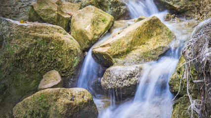 Naklejka na ściany i meble long exposure of creek water, with autumn leaf on rock.