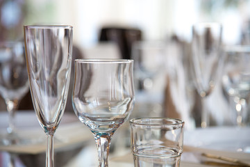 Table setting in the restaurant, including glasses for wine, champagne and cognac, napkins and plates for guests