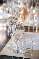 Table setting in the restaurant, including glasses for wine, champagne and cognac, napkins and plates for guests