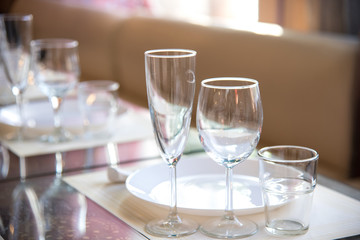 Table setting in the restaurant, including glasses for wine, champagne and cognac, napkins and plates for guests