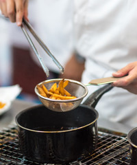 Chef is cooking french fries in the kitchen, Chef cooking fried potato in pan