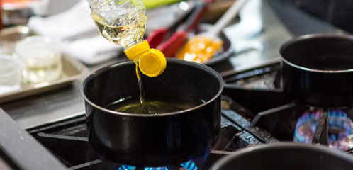 Chef pouring oil in frying pan, Chef cooking food in the kitchen