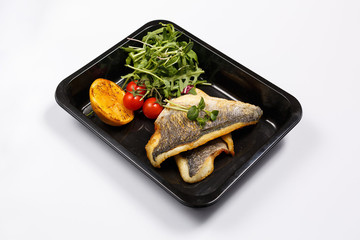 Isolated dish of cooked white fish with cherry tomatoes and arugula. Asian seafood concept.
