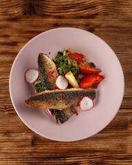 Fried mackerel fish with vegetable garnish: spinach in coconut milk, radish, onion and baked tomatoes