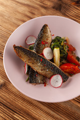 Fried mackerel fish with vegetable garnish: spinach in coconut milk, radish, onion and baked tomatoes