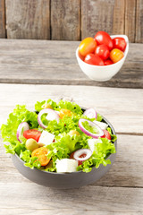 Salad with vegetables on wooden background