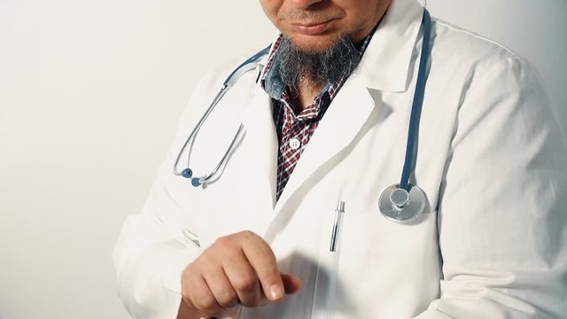 Physician holding a digital tablet, looking at the camera, tilt