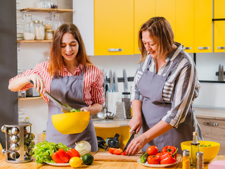 Family leisure. Mother and daughter having fun in kitchen, cooking together, using organic...