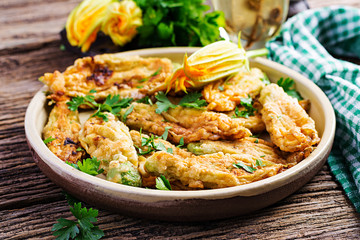 Fried zucchini flowers stuffed with ricotta and green herbs. Vegan food. Italian cuisine.