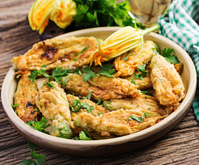 Fried zucchini flowers stuffed with ricotta and green herbs. Vegan food. Italian cuisine.