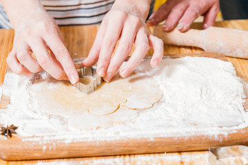 Culinary course. Closeup of woman hands cutting dough, making gingerbread biscuits.