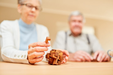 Seniors with dementia play with a wooden puzzle