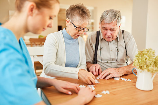 Senior couple with dementia playing puzzle