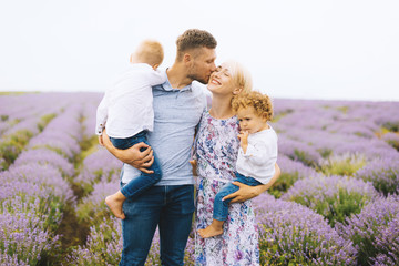 Happy young family are enjoying their time together in the middle os lavender field.