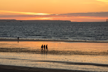  Romantic walk of people before sunset on the picturesque beach of Saint Malo. Brittany, France